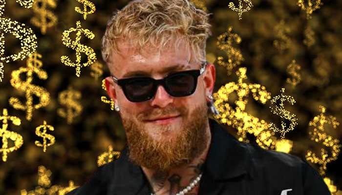 Jake paul with blonde hair, beard, and sunglasses, set against a background of golden dollar signs symbolizing jake paul net worth.