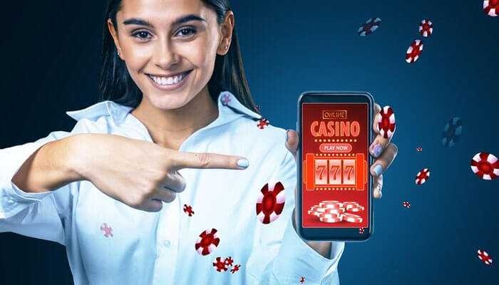 Smiling woman pointing at a smartphone displaying the pin up apk online casino app, with poker chips floating around her.