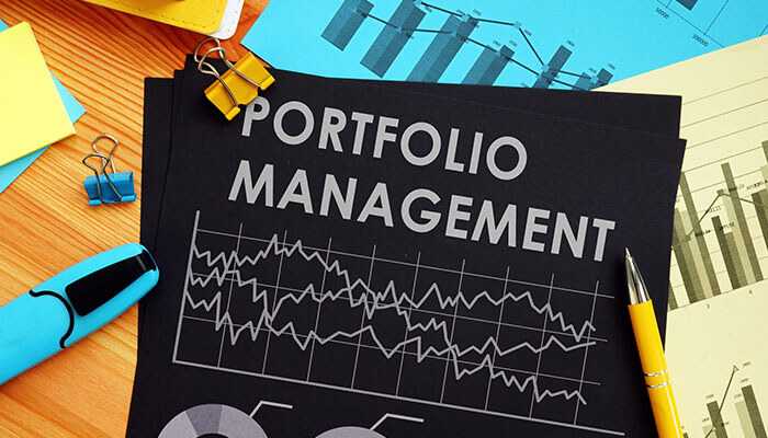 Portfolio management documents with financial charts and graphs, along with office supplies, highlighting strategies for real estate portfolio and investment growth