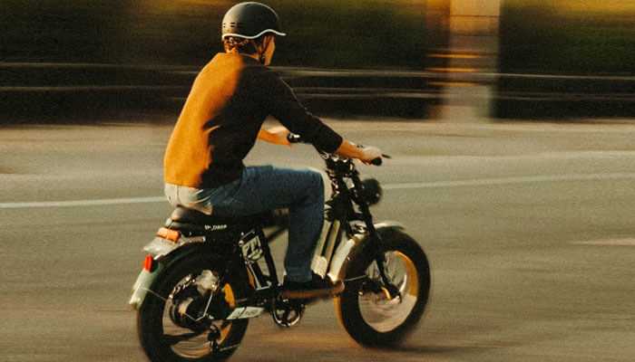 Person riding an electric bike on a sunny day, showcasing stylish electric bikes, comfortable commute ideal for urban living and sustainable transportation