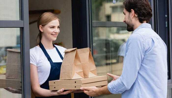 A delivery worker hands over packages to a customer, which represents workiz service management software.