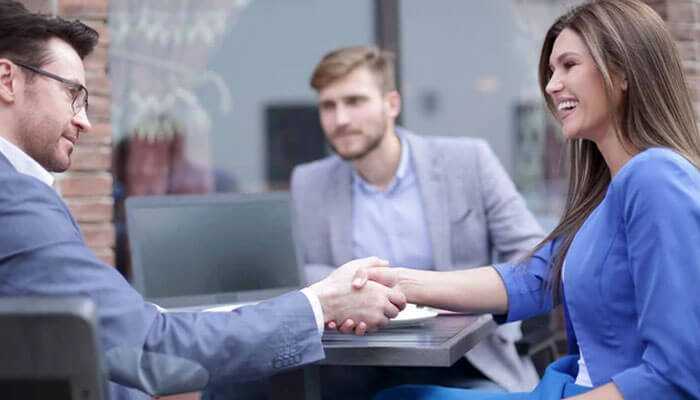 Businessmen shaking hands in a meeting-a representation of eor in international employment and workforce expansion.