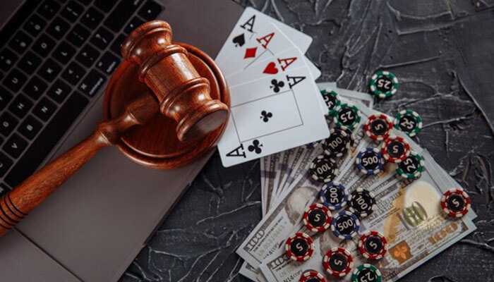 A gavel on a laptop beside playing cards, cash, and poker chips-all implying regulation of online gambling and australian online casinos.