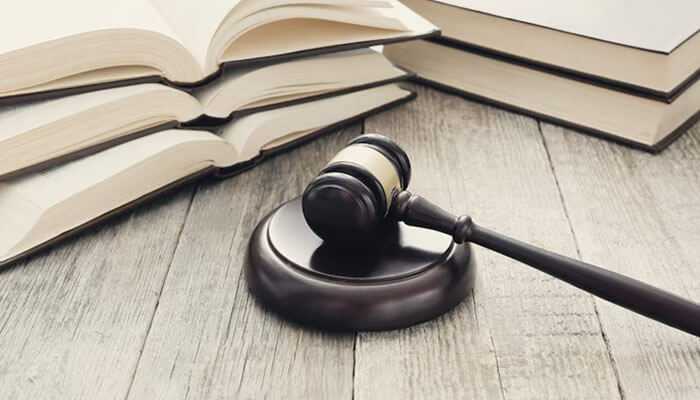 Gavel placed on a wooden table with open law books in the background, symbolizing legal representation by a new orleans spinal cord injury lawyer