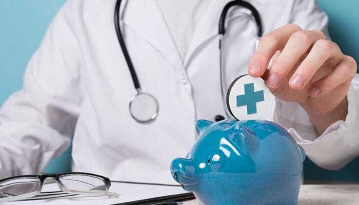 Doctor putting a coin with a medical cross into a blue piggy bank, symbolizing the 3-month rule in healthcare savings.