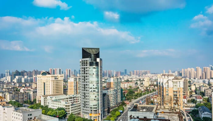 A busy cityscape with skyscrapers, a clear blue sky, and an urban hub of activities-a city with 2 bhk flats in mumbai.