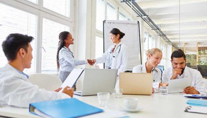 Medical professionals working together in a bright room, representing partnering with a patient recruitment agency.