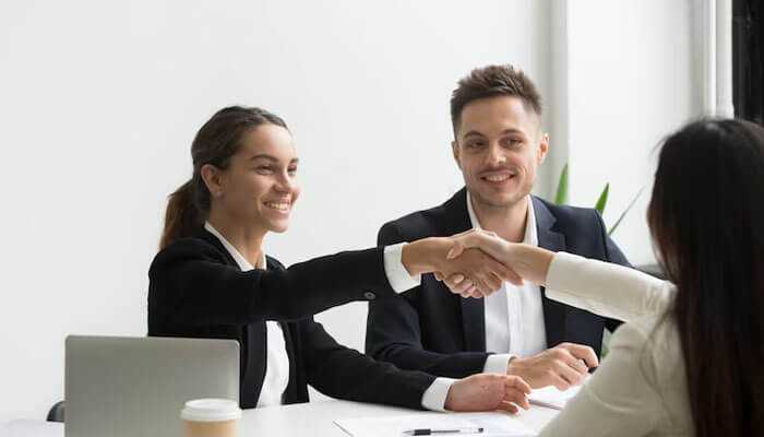 Professionals shaking hands in a meeting, showing agreement and success of the it recruitment agencies in india.