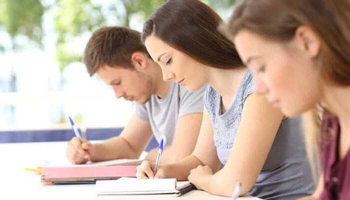 Students focused on writing notes, representing study preparation and learning in gmat classes in mumbai for exam success.