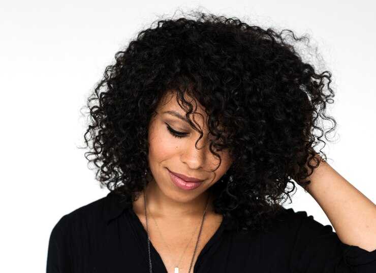 Woman with natural, curly deep wave hair wearing a glueless wig