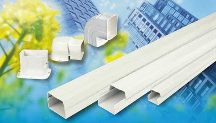 Accessories for pvc cable ducts and wiring solution covers against the background of a modern building with greenery.