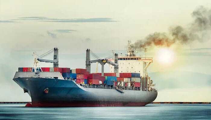 Smoke-emitting cargo ship with containers, symbolic of global logistics and fulfillment services under a setting sun.