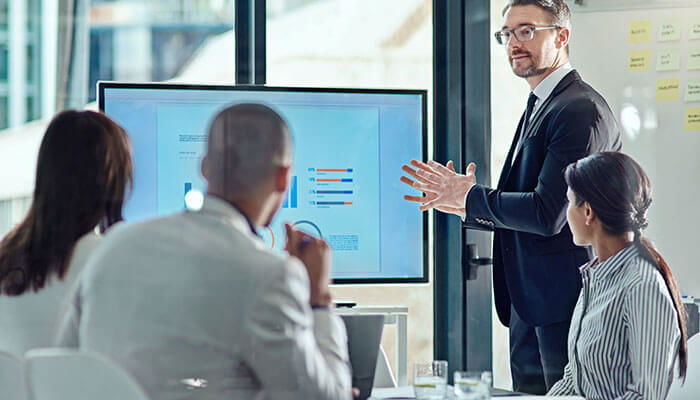 New business technology business professional presenting data charts during a meeting with colleagues in a modern office setting