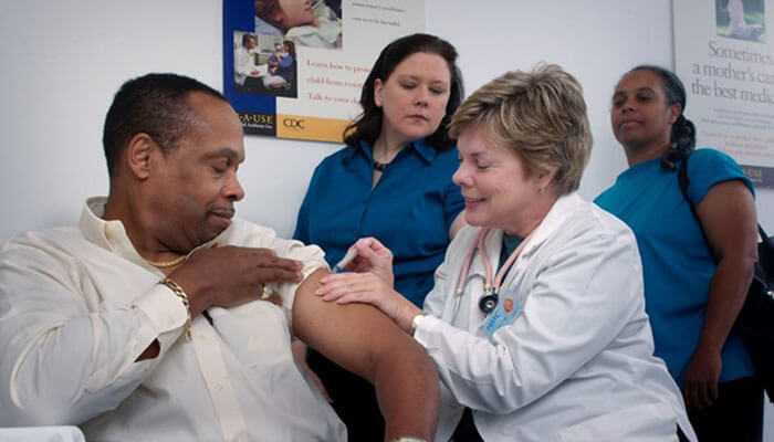 Healthcare professional vaccinating a patient; in each, examples show how emr solutions improve patient care and team collaboration.