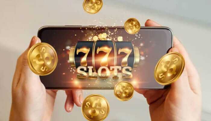 A person holding a smartphone displaying a 777 slots game with golden coins, depicting online slots for real money.