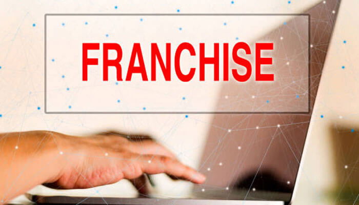 Franchise concept with a person typing on a laptop, highlighting in bold red text the words franchise and trademark registration.