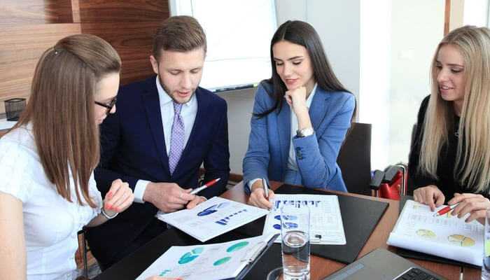 Hiring a coo qualities – a professional business team analyzing reports and discussing strategies in a corporate meeting.