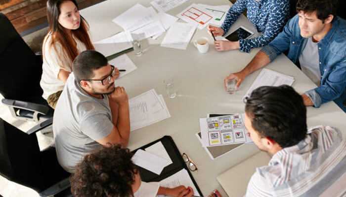 Marketing team collaborating on strategy and planning, showcasing the advantage of systemized client acquisition for business growth.