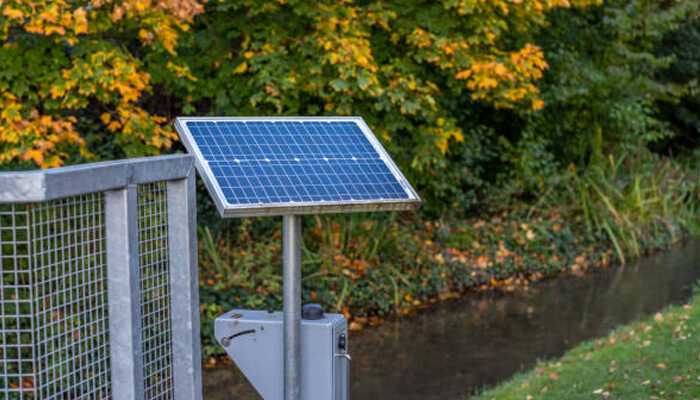 Solar powered gate opener for driveway access, installed near a peaceful garden area, harnessing renewable energy for automated entry.