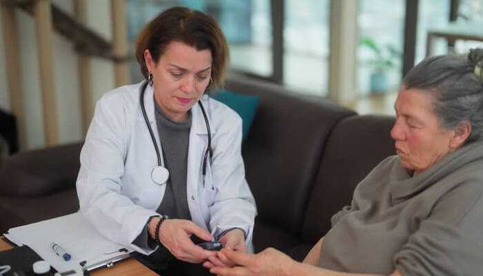 A doctor carefully checking the blood sugar levels of a chronic patient at home, emphasizing attentive care and management for chronic patients.
