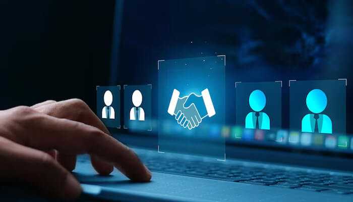 A digital handshake icon on a laptop screen representing online strategies companies use to buy engagement and foster virtual customer trust.