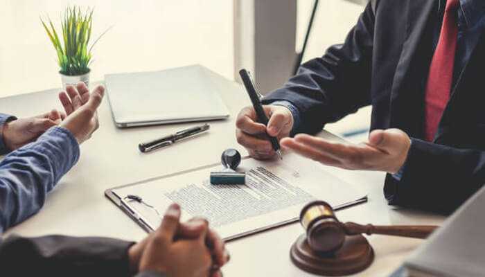 Accident attorneys discussing legal documents and case details with clients during a personal injury consultation.
