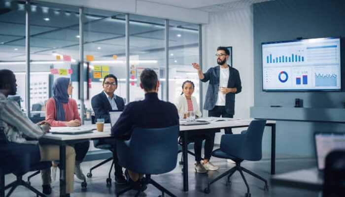 Business team in a meeting, presenting data analysis and insights on hotel occupancy rates in a modern office setting.