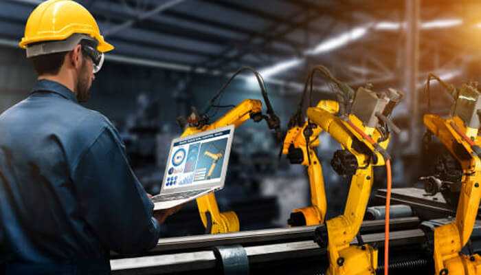 Engineer managing robotic automation on a factory floor, illustrating how welding to warehousing innovations drive smart operations.