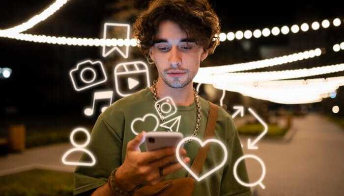 Young man engaging with tiktok on his smartphone, surrounded by interactive social media icons in a vibrant nighttime setting.