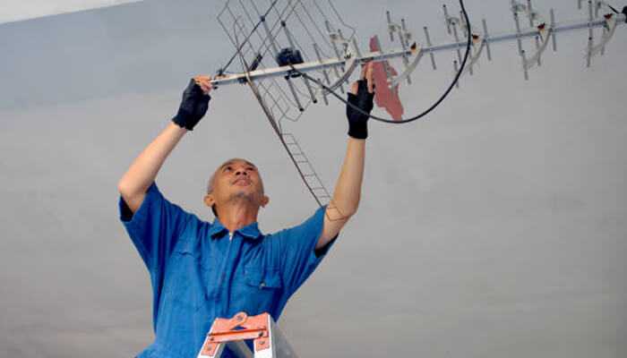 Professional conducting indoor tv aerials installation, aligning the antenna for best signal quality.