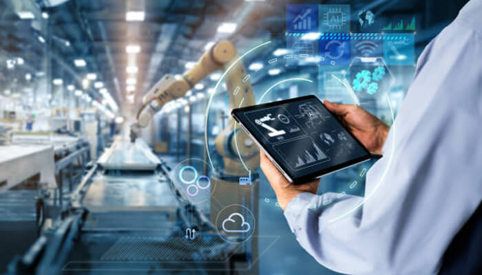A professional monitoring factory operations using a tablet, displaying real-time factory insights through digital interfaces and data analytics.