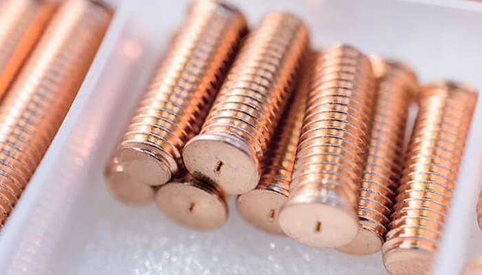 Close-up view of copper threaded welding studs organized in a tray, showcasing high-quality fasteners for precision welding.