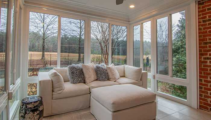 Bright and airy living space filled with greenery and large windows for ventilation, allowing fresh air and sunlight to enhance indoor comfort.