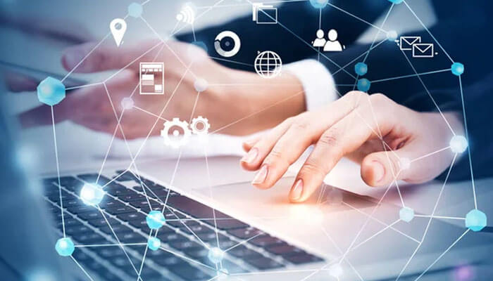 Close-up of hands typing on a laptop with digital connections and technology icons, representing the role of backlinks in online networking and seo.